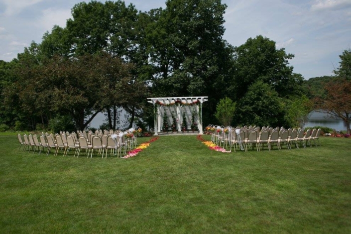 An outdoor wedding ceremony set up in a grassy area.