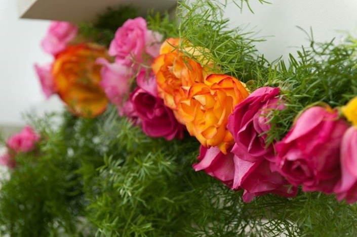A garland of flowers and greenery is hanging on a wall.