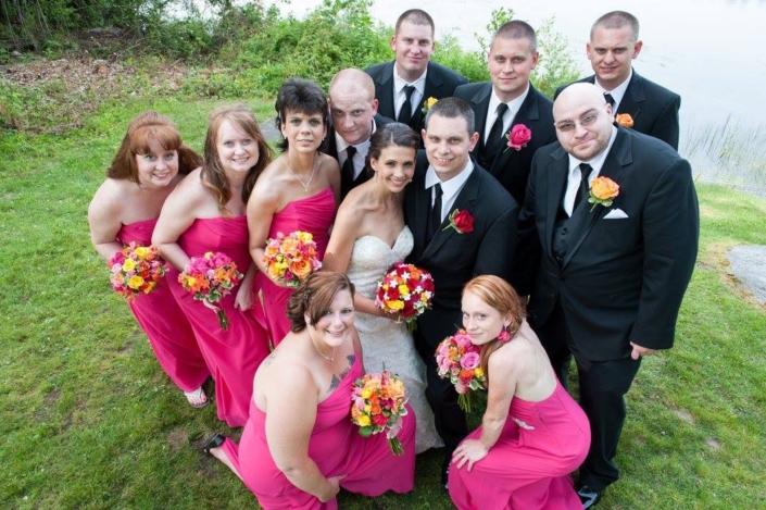 A group of bridesmaids and groomsmen posing for a photo.