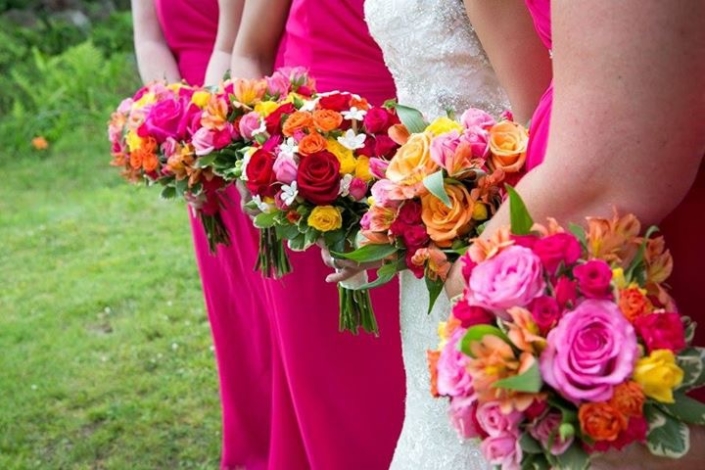 The bridesmaids are holding colorful bouquets.