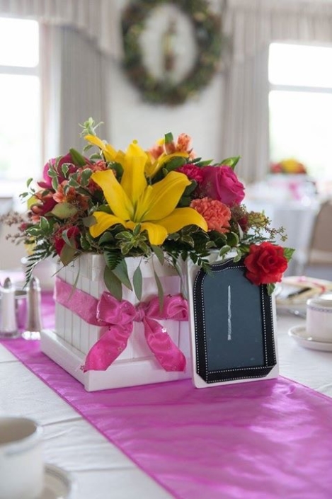 A table with flowers and a phone on it.
