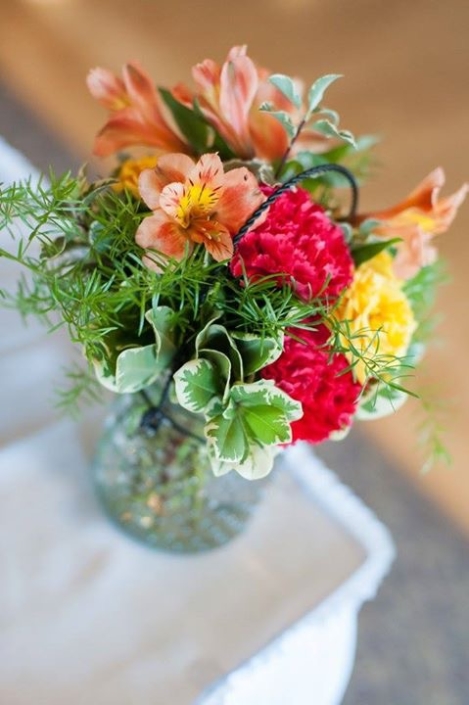 An arrangement of flowers in a glass vase on a table.