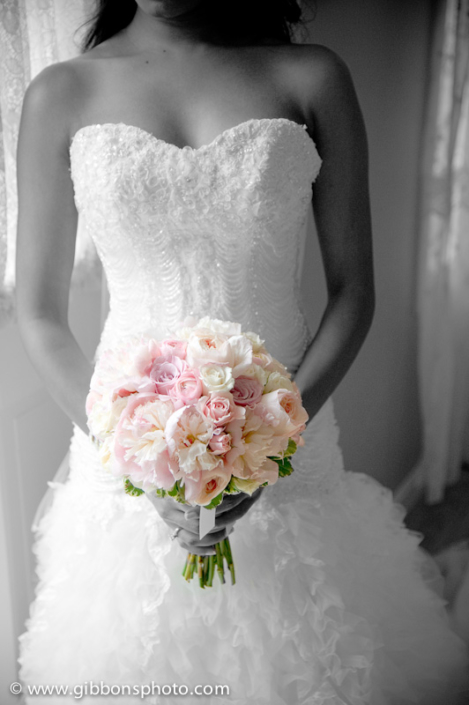 A bride holding a bouquet of pink and white flowers.