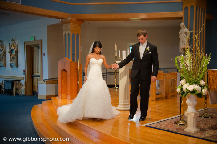 A bride and groom walking down the aisle of a church.