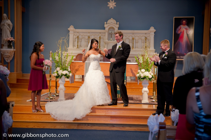 A bride and groom standing in front of a church.