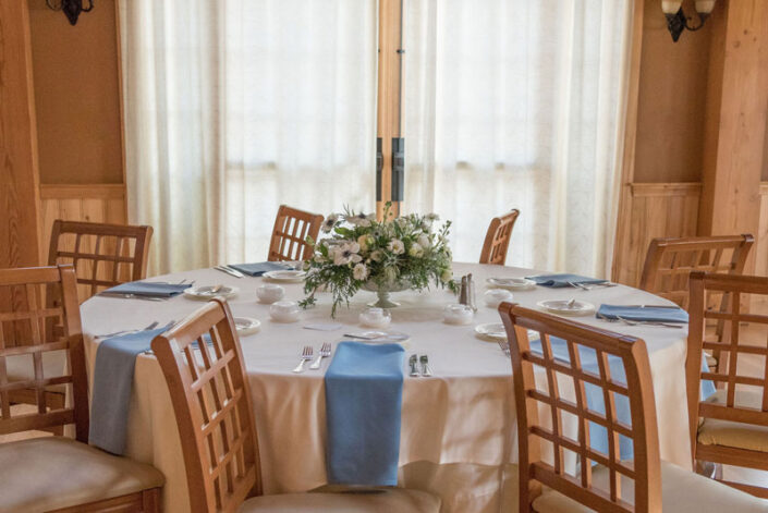 A wooden table set with blue and white linens.