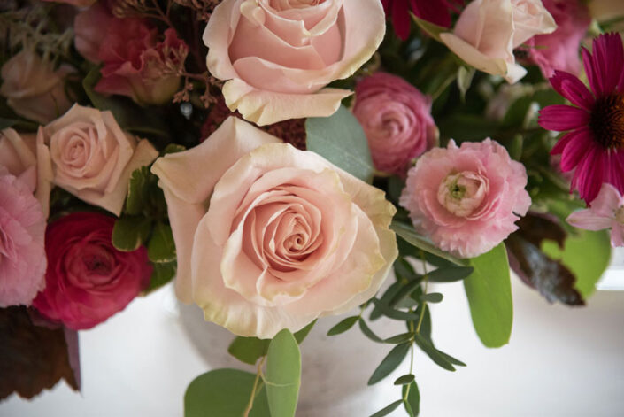 Pink roses in a vase on a table.