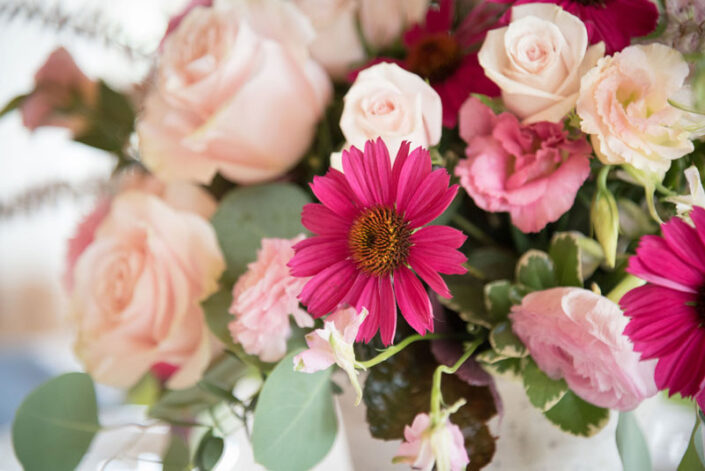 Pink and white flowers in a vase on a table.