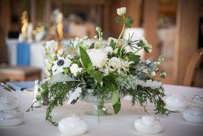 An arrangement of white and green flowers on a table.