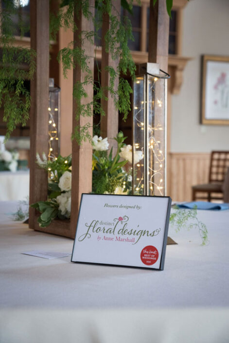 A table with a sign on it for a wedding.