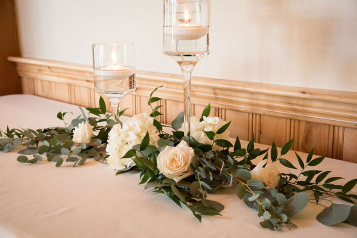 Eucalyptus and white flowers on a table.