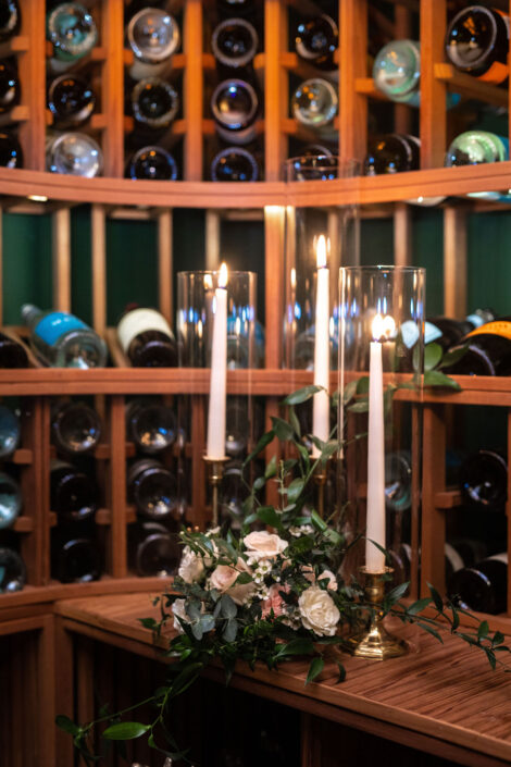 A wine cellar filled with candles and flowers.