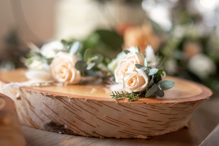 A bouquet of flowers sits on top of a piece of wood.