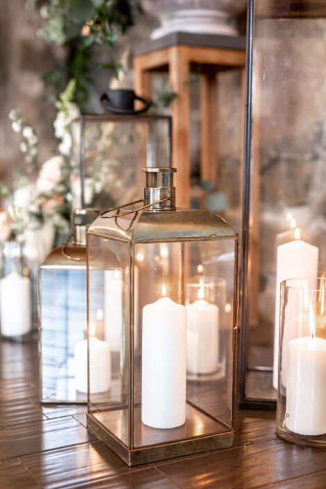 Gold lanterns with candles on a wooden table.