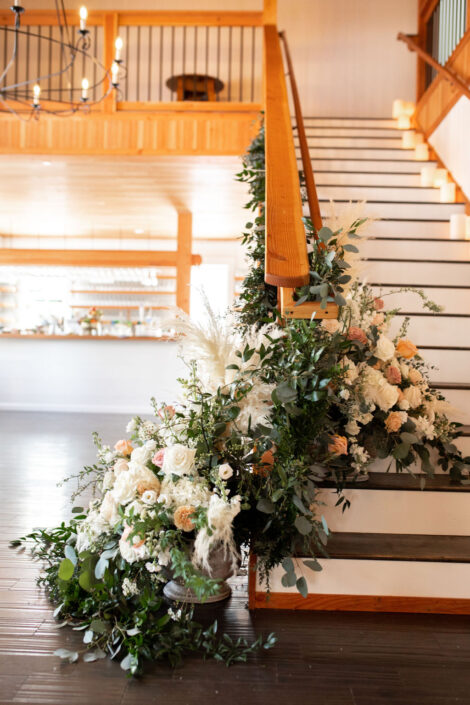 A staircase decorated with flowers and greenery.
