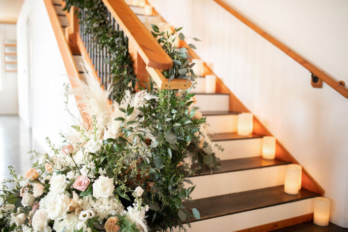 A staircase decorated with flowers and candles.