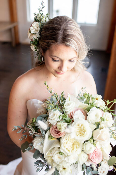 A bride holding a bouquet of white and pink flowers.