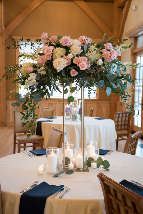 tall glass vase with pink roses and candles