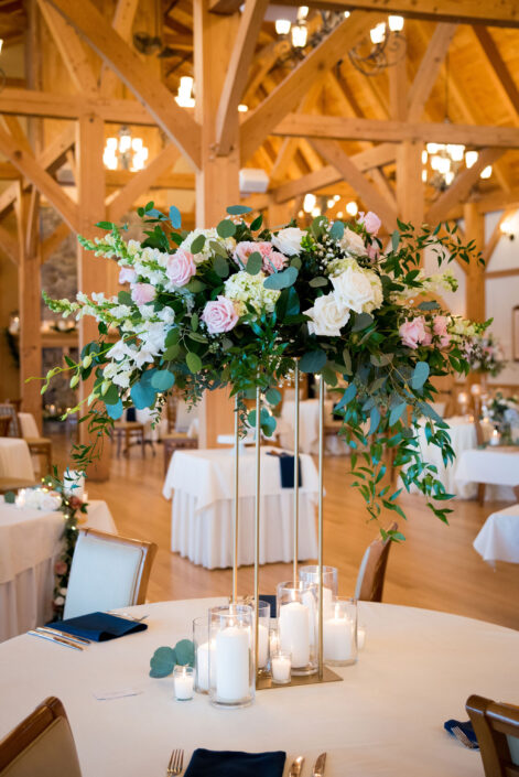 A wedding reception with candles and flowers in a wooden room.