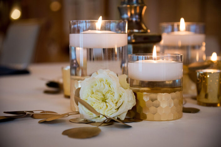 A table with candles and flowers on it.
