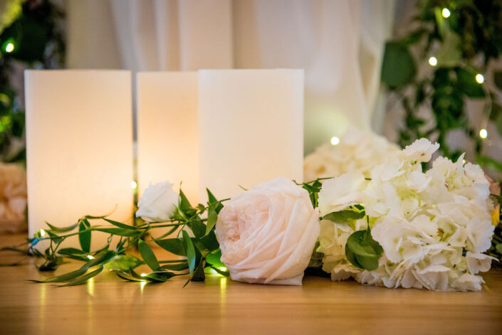 Candles and flowers on a wooden table.