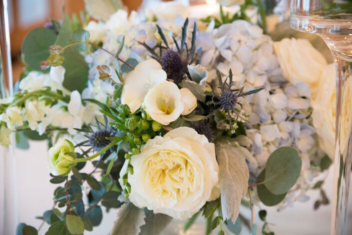 An arrangement of blue and white flowers on a table.