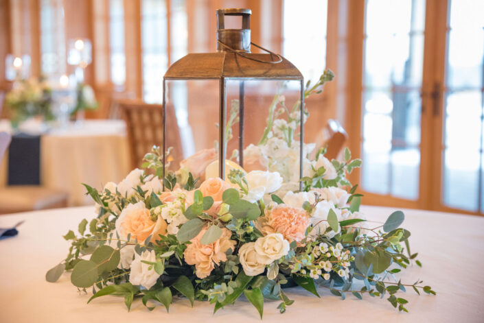 A centerpiece with flowers and greenery on a table.