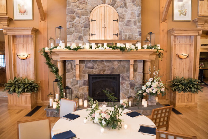 A stone fireplace in a room with a table and chairs.