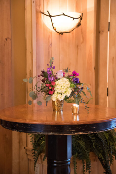 A wooden table with flowers on it.