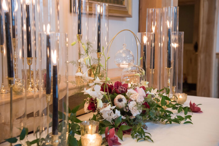 An arrangement of flowers and candles on a table.