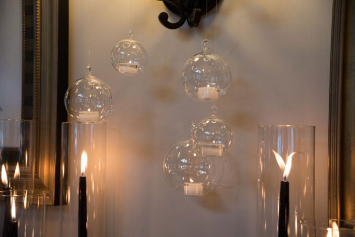 Glass candle holders hanging on a wall.