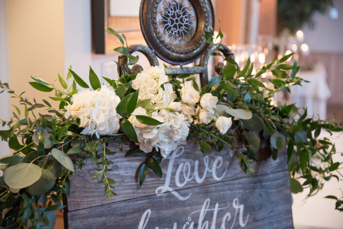 A wooden sign with the words love and laughter on it.