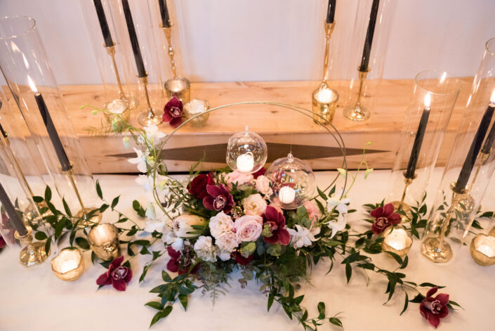 A table with candles and flowers on it.