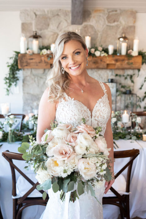 A bride holding a bouquet in front of a fireplace.