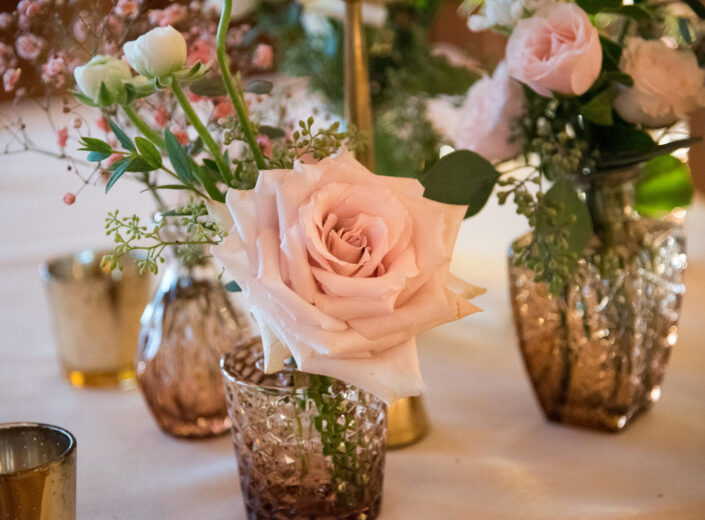 Pink roses in vases on a table.