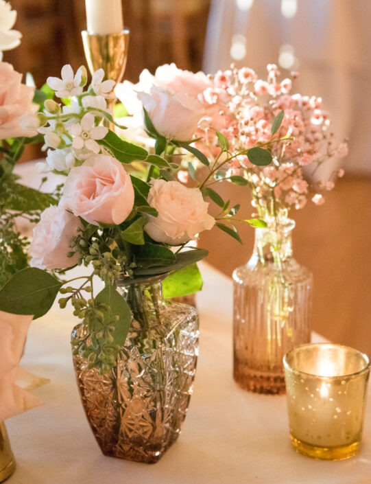 A table with pink flowers and candles on it.