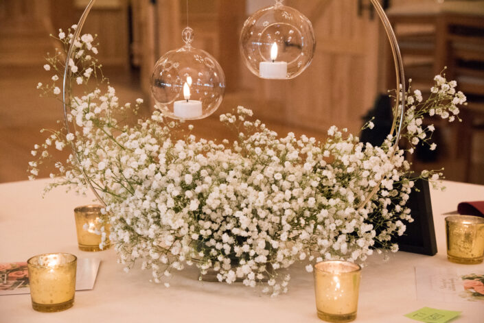 An arrangement of baby's breath and candles on a table.