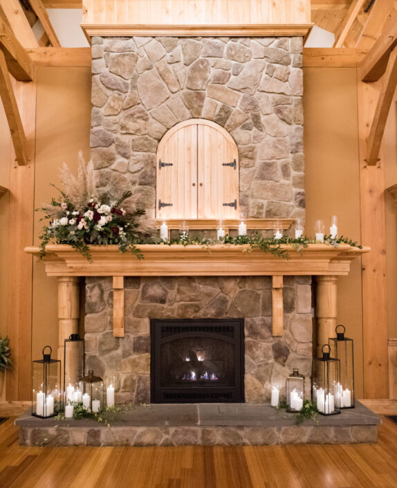 A stone fireplace with candles on it.