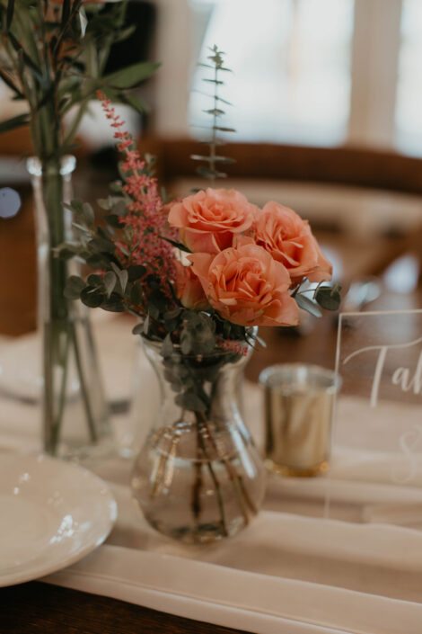 A table setting with flowers and a sign.