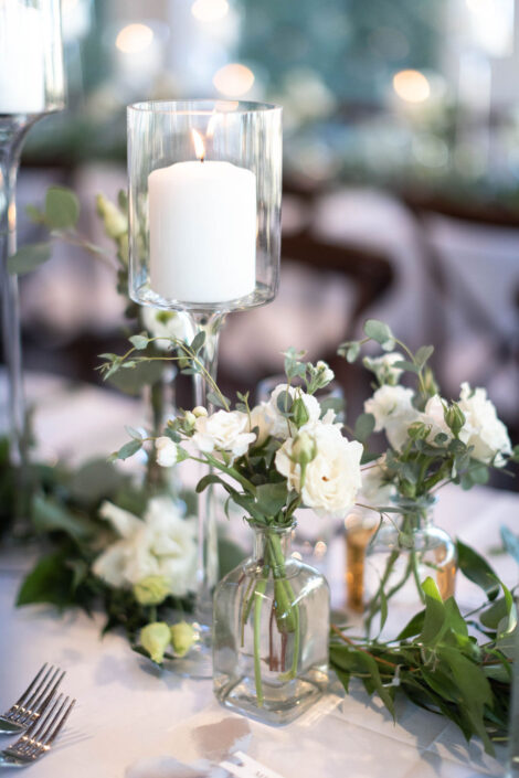 A table setting with white flowers and candles.