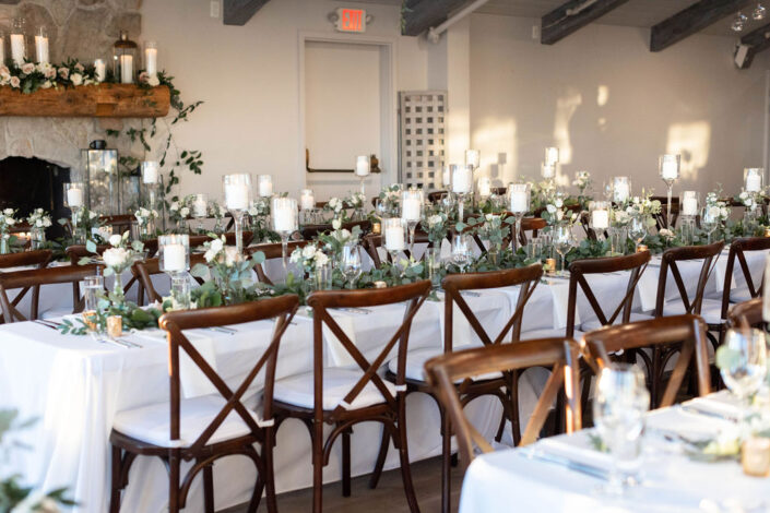 A wedding reception set up with white linens and candles.