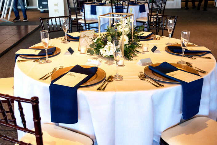A white tablecloth with blue and white napkins.