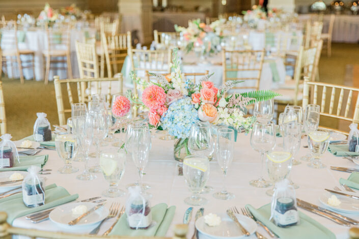 A wedding reception table set up with flowers and plates.
