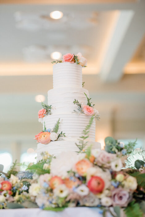 A white wedding cake is sitting on top of a table.