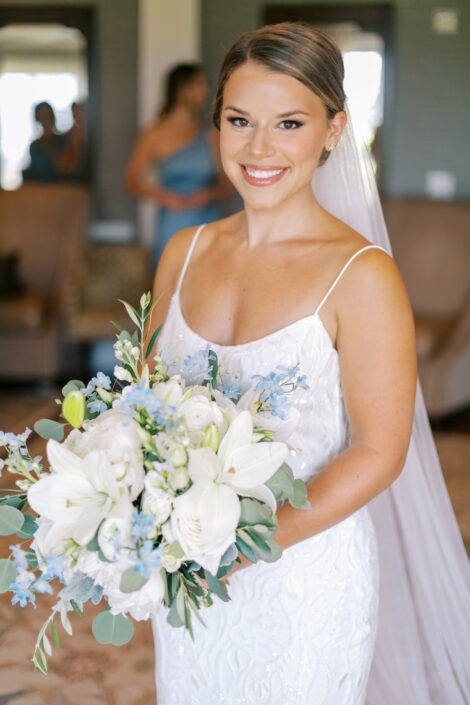 A bride holding a bouquet of blue and white flowers.