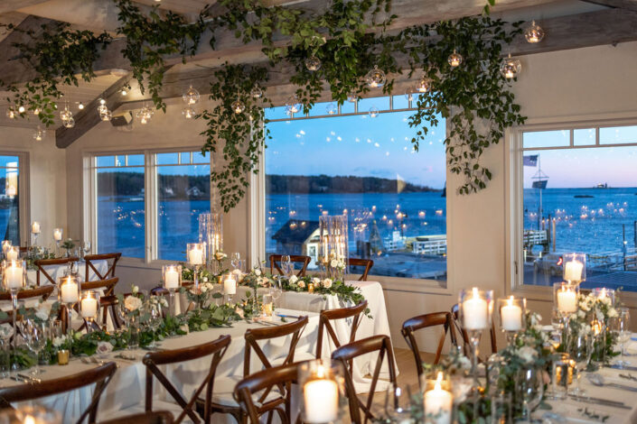 A wedding reception set up with candles and a view of the ocean.