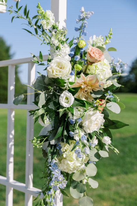 A wedding arch decorated with blue and white flowers.