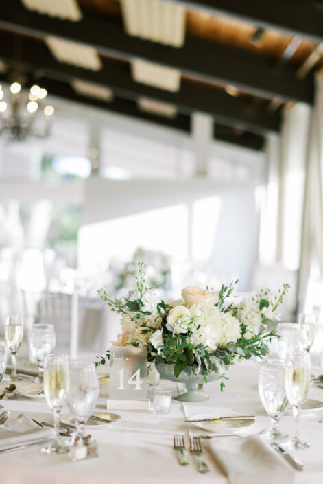 A white table setting with white plates and silverware.