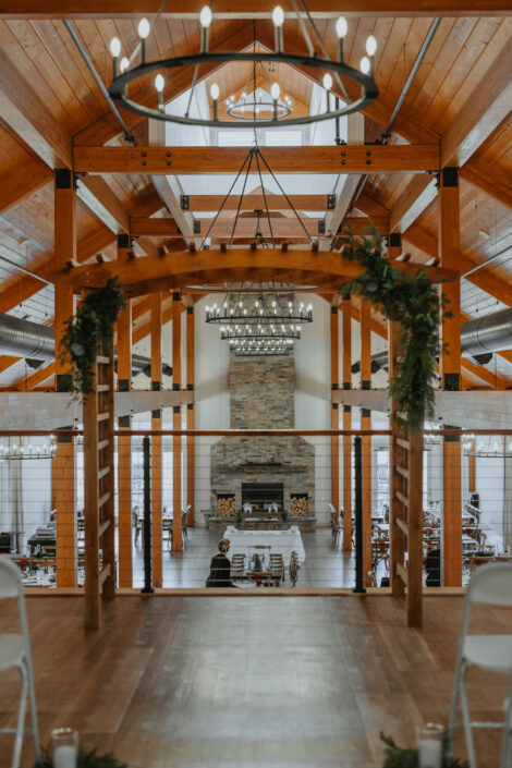 A wedding ceremony in a barn with chairs and a fireplace.